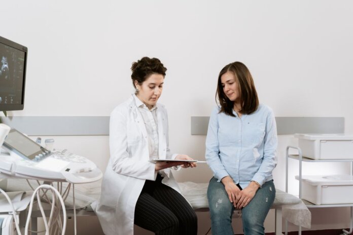 A pregnant woman consulting with a gynecologist in a medical facility. A pregnant woman consulting with a gynecologist in a medical facility.