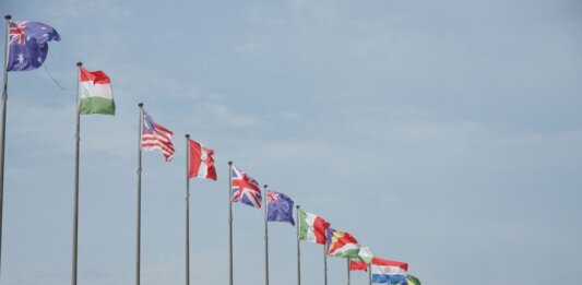 Канада и ещё 11 партнёров выступили с совместным заявлением о санкциях против КНДР A row of international flags on flagpoles symbolizing global unity and diplomacy.