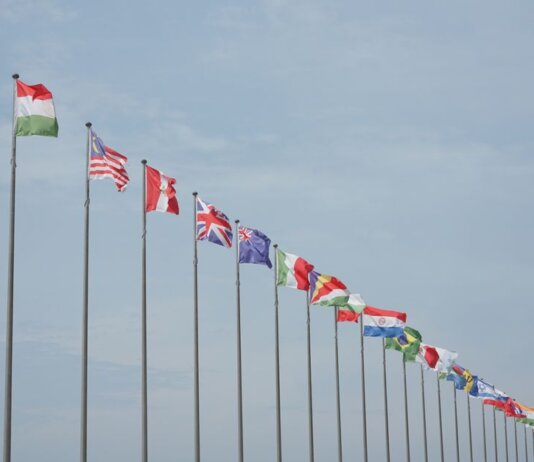 A row of international flags on flagpoles symbolizing global unity and diplomacy.