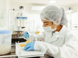 A scientist wearing protective gear performs a meticulous experiment in a laboratory setting.