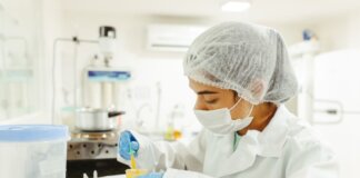 A scientist wearing protective gear performs a meticulous experiment in a laboratory setting.