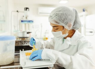 A scientist wearing protective gear performs a meticulous experiment in a laboratory setting.