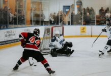 A thrilling hockey game captured indoors with players in action and spectators watching keenly.