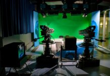 A TV studio setup featuring cameras and a green screen for production purposes.