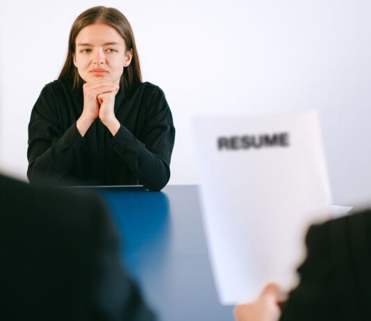 Консерваторы: доля канадцев на рынке труда упала до минимума за 29 лет A woman in a job interview facing two employers with a focus on her resume.
