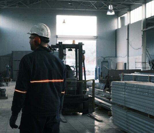 A worker in protective gear supervises operations in a modern Ankara factory.