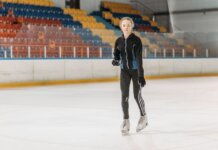 A young woman glides gracefully on an indoor ice rink, showcasing her skating skills.