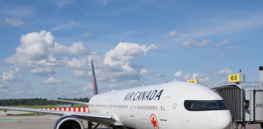 Air Canada и United Airlines хотят обновить совместное предприятие на рейсах в США Air Canada Boeing 777 airplane parked at an airport gate under a clear blue sky.