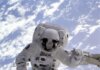 Джереми Хансен рассказал в Western University об уроках лунной миссии Artemis II Astronaut conducting a spacewalk with Earth in the background, showcasing outer space exploration.