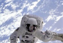 Astronaut conducting a spacewalk with Earth in the background, showcasing outer space exploration.