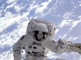 Astronaut conducting a spacewalk with Earth in the background, showcasing outer space exploration.