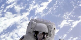 Astronaut conducting a spacewalk with Earth in the background, showcasing outer space exploration.