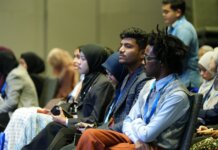 Attendees seated attentively at a professional business conference indoors.