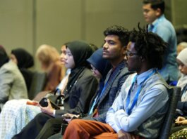 Attendees seated attentively at a professional business conference indoors.