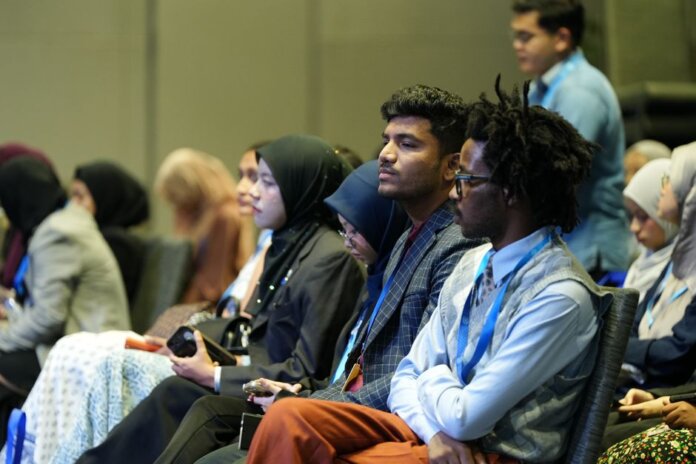 Attendees seated attentively at a professional business conference indoors.