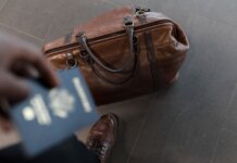 Brown leather bag with passport in an airport setting, ideal for travel and fashion themes.