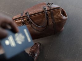 Brown leather bag with passport in an airport setting, ideal for travel and fashion themes.