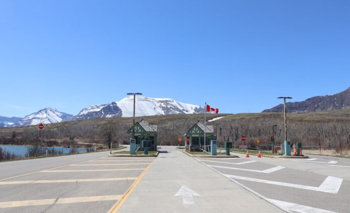 Canadian border crossing amidst stunning snow-capped mountains and clear blue sky. Canadian border crossing amidst stunning snow-capped mountains and clear blue sky.