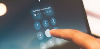 Close-up of a finger entering a passcode on a smartphone security screen.