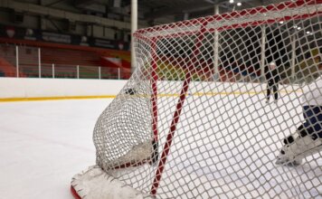 «Виннипег Джетс» уступили «Монреалю» 1:2 в Heritage Classic и проиграли пятый матч подряд Close-up of a hockey goal on an indoor rink with players practicing in the background.