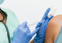 Close-up of a nurse in gloves giving a vaccination to a patient.