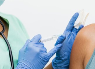 Close-up of a nurse in gloves giving a vaccination to a patient.