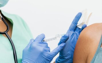 Британская Колумбия начинает вакцинацию к сезону респираторных вирусов Close-up of a nurse in gloves giving a vaccination to a patient.