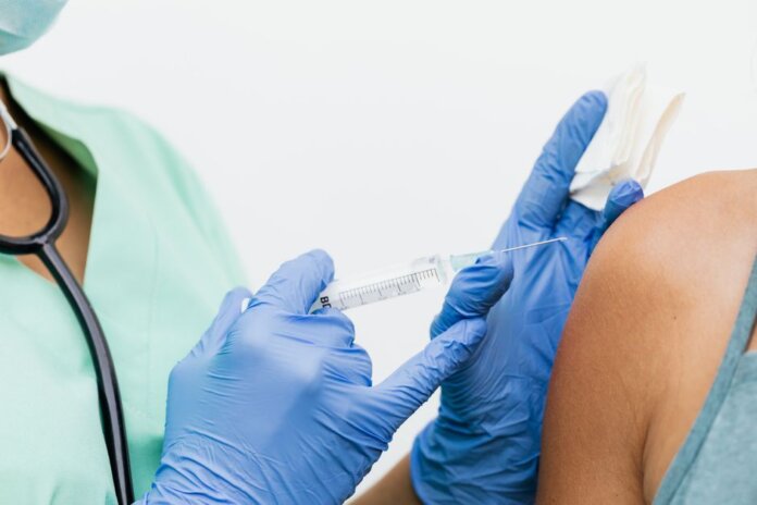 Close-up of a nurse in gloves giving a vaccination to a patient. Close-up of a nurse in gloves giving a vaccination to a patient.