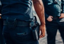 Полиция Онтарио приостанавливает работу с Crime Stoppers после утечки данных Close-up of a police officer's firearm securely holstered at the waist, conveying professionalism and readiness.