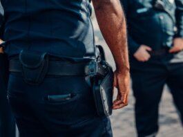 Close-up of a police officer's firearm securely holstered at the waist, conveying professionalism and readiness.