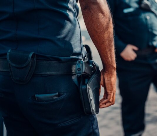 Close-up of a police officer's firearm securely holstered at the waist, conveying professionalism and readiness.