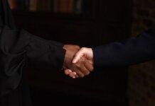 Close-up of diverse individuals shaking hands, symbolizing business agreement.
