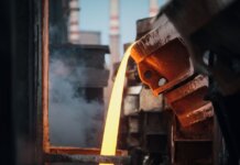 Close-up of molten metal pouring in a foundry, showcasing industrial processes.