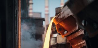 Close-up of molten metal pouring in a foundry, showcasing industrial processes.
