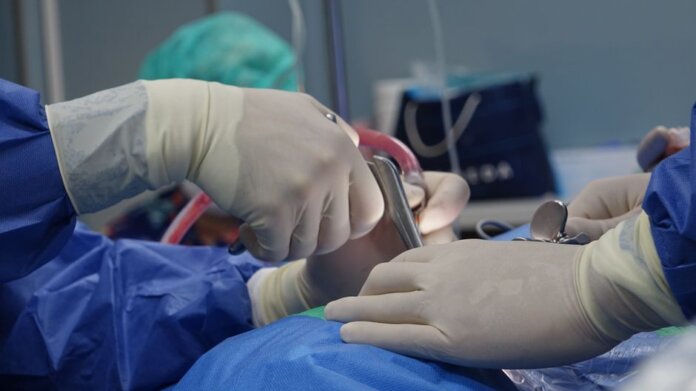 Close-up of surgeons operating in a hospital theater setting with precision. Close-up of surgeons operating in a hospital theater setting with precision.