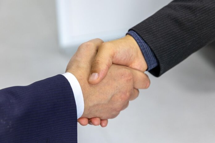 Close-up of two businessmen shaking hands, symbolizing agreement and partnership. Close-up of two businessmen shaking hands, symbolizing agreement and partnership.