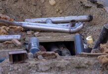 Close-up of urban pipe installation at a construction site, showing various pipes and materials.