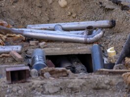Close-up of urban pipe installation at a construction site, showing various pipes and materials.