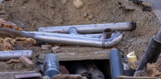 Close-up of urban pipe installation at a construction site, showing various pipes and materials.