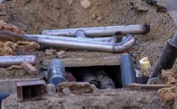 Close-up of urban pipe installation at a construction site, showing various pipes and materials.