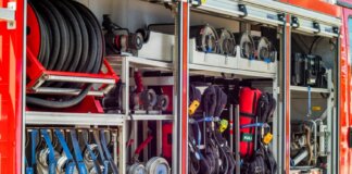 Close-up view of fire truck equipment storage showcasing hoses, tools, and gear.