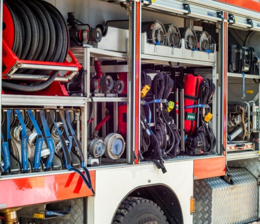 Close-up view of fire truck equipment storage showcasing hoses, tools, and gear.