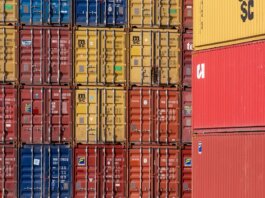 Colorful shipping containers stacked in a port for transport logistics.