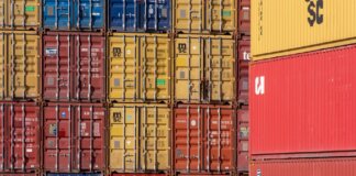 Colorful shipping containers stacked in a port for transport logistics.
