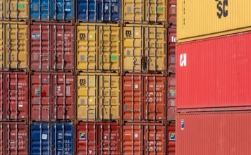Минфин Канады обсудил с бизнесом и профсоюзами ответ на пошлины США Colorful shipping containers stacked in a port for transport logistics.