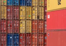 Colorful shipping containers stacked in a port for transport logistics.