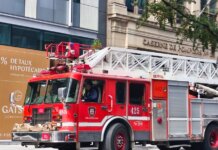 Detailed view of a red fire truck in Montreal with building background.