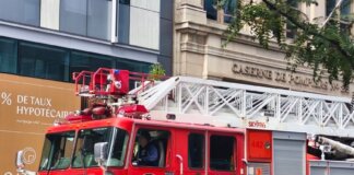 Detailed view of a red fire truck in Montreal with building background.