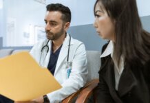 Doctor discusses health records with a patient in a clinical setting.