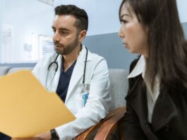 Doctor discusses health records with a patient in a clinical setting.